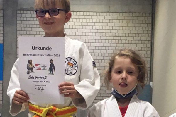 Junger Judoka mit Urkunde auf dem Podest bei den Bezirksmeisterschaften U11 im Judo.